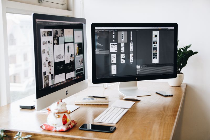Tasarım yazılımlarının açık olduğu çift monitörlü çalışma alanı